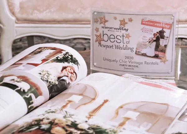 A 'Best of Newport Wedding 2020' award plaque for Uniquely Chic Vintage Rentals displayed next to an open magazine.