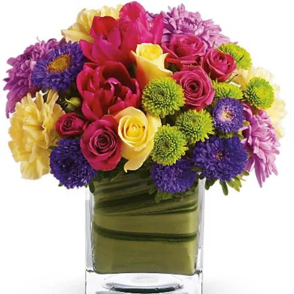 A colorful mixed bouquet of roses, chrysanthemums, and other flowers arranged in a clear glass vase.