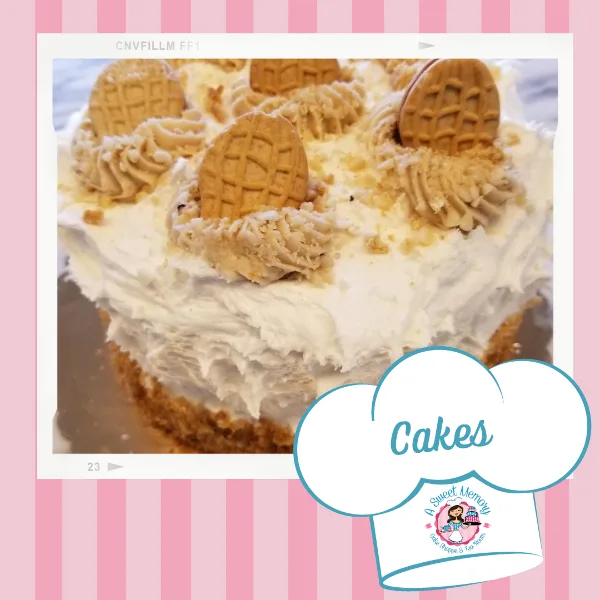 A close-up of a white frosted cake decorated with piped cream and whole cookies.