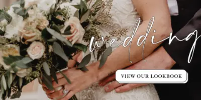 A bride in a white dress holding a bouquet of white roses and greenery, with the word 'weddings' written in script.
