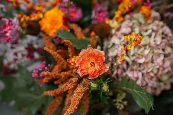 Close-up of a vibrant floral arrangement with orange and pink flowers and greenery