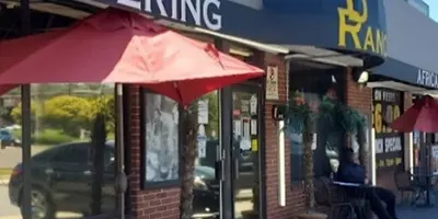Exterior view of De Ranch Restaurant & Bar storefront with a 'CATERING' sign and outdoor seating.