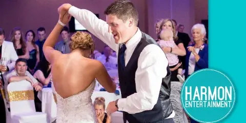 A bride and groom dancing at a wedding reception with guests in the background, featuring the Harmon Entertainment logo.
