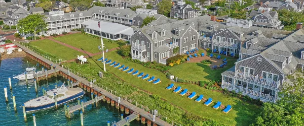 Aerial view of the White Elephant Hotel resort on Nantucket, showing the main building, lawn with a white elephant statue, and a marina with boats.
