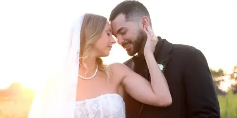 A bride and groom sharing an intimate moment outdoors during golden hour.