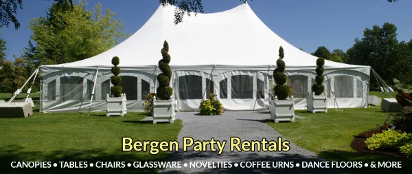 A large white event tent set up on a grassy lawn with tables and topiary decorations.