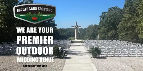 Outdoor wedding ceremony setup with rows of white chairs and a large cross in the background.