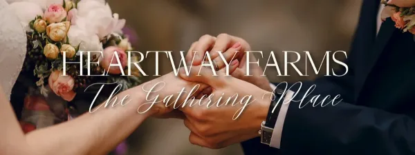 Close-up of a bride and groom clasping hands during a wedding ring exchange, with a floral bouquet visible.