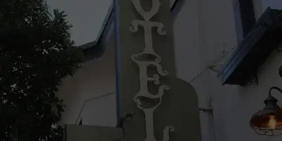 Exterior sign for the San Benito Hotel attached to a building facade.
