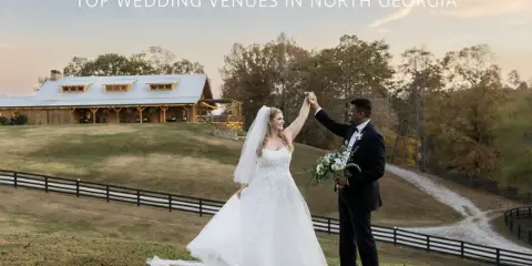 A bride and groom dancing outdoors in front of a rustic wooden barn venue during the golden hour.