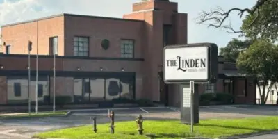 Exterior view of The Linden venue building with its sign visible in the foreground.