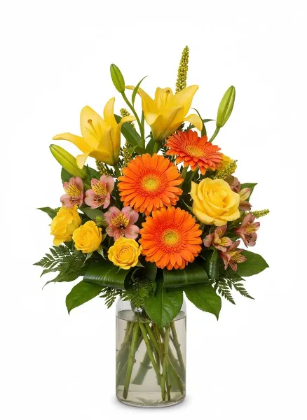 A floral arrangement featuring yellow lilies, orange gerbera daisies, and yellow roses in a clear glass vase.
