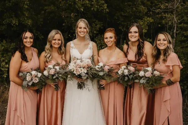 A bride and bridesmaids holding floral bouquets