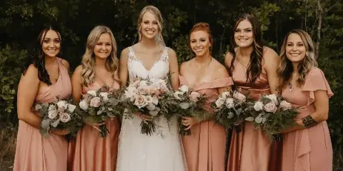 A bride and bridesmaids holding floral bouquets