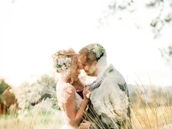 A bride and groom embracing in a field with floral details