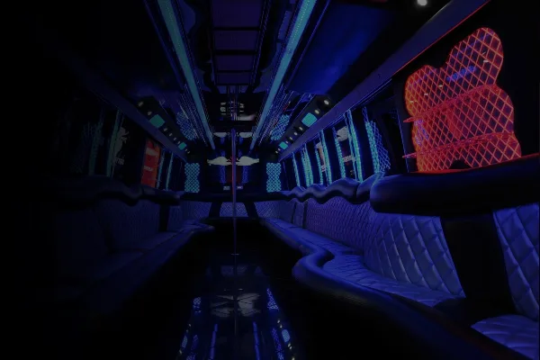 Interior view of a party bus featuring blue ambient lighting and white leather bench seating.