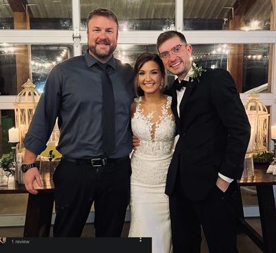 DJ Lee Jeffrey posing with a bride and groom at a wedding reception.