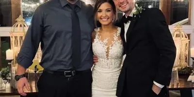 DJ Lee Jeffrey posing with a bride and groom at a wedding reception.