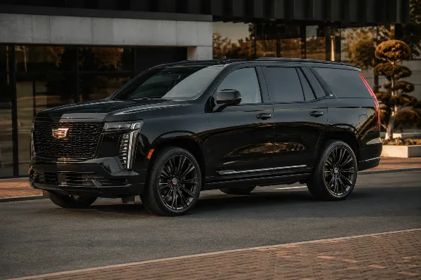 A black luxury SUV parked in front of a modern building.