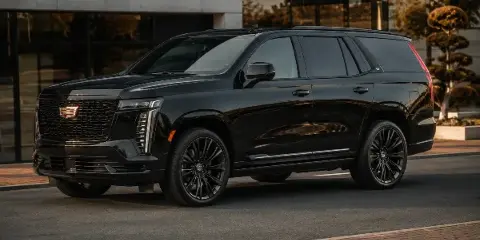 A black luxury SUV parked in front of a modern building.