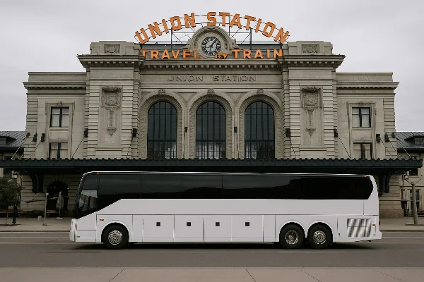 A white luxury charter bus parked in front of a building.