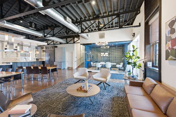 Interior view of a modern event space with vaulted ceilings, exposed ductwork, and a lounge area.