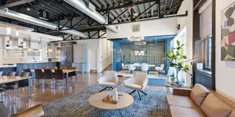Interior view of a modern event space with vaulted ceilings, exposed ductwork, and a lounge area.