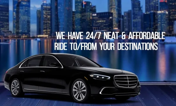 Black luxury sedan parked in front of a city skyline at dusk