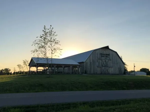 Exterior view of the Tanglewood Events Barn at sunset with a covered outdoor shelter.