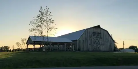 Exterior view of the Tanglewood Events Barn at sunset with a covered outdoor shelter.