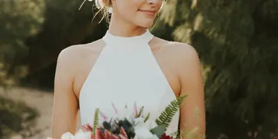 Bride with styled updo and makeup holding a bouquet