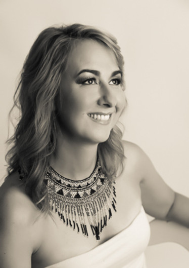 Portrait of a woman with styled hair and a statement necklace