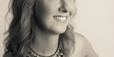 Portrait of a woman with styled hair and a statement necklace