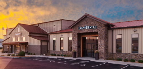 Exterior view of a commercial building with a sign reading 'EVENT CENTER' at dusk.
