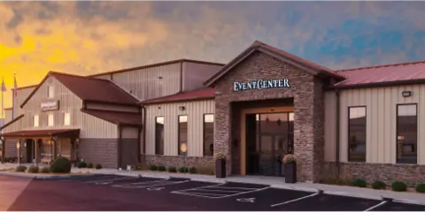 Exterior view of a commercial building with a sign reading 'EVENT CENTER' at dusk.