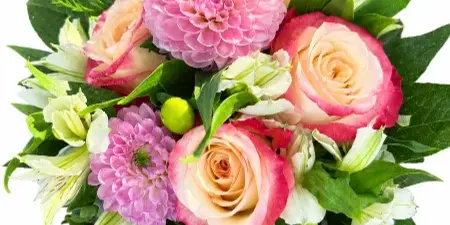 A close-up of a mixed flower arrangement featuring pink and peach roses, a large pink dahlia, and white alstroemeria with green foliage.