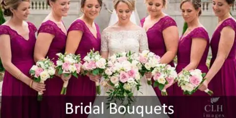 A bride and bridesmaids in purple dresses holding pink and white floral bouquets.