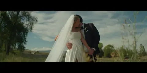 A bride and groom sharing a romantic moment in a Montana field, captured in a cinematic wedding photography style.