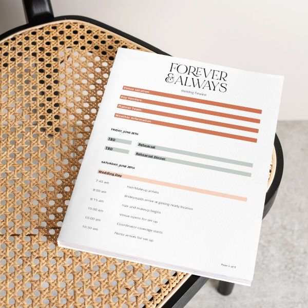 A branded wedding timeline document from Forever & Always Event Planning resting on a woven chair.