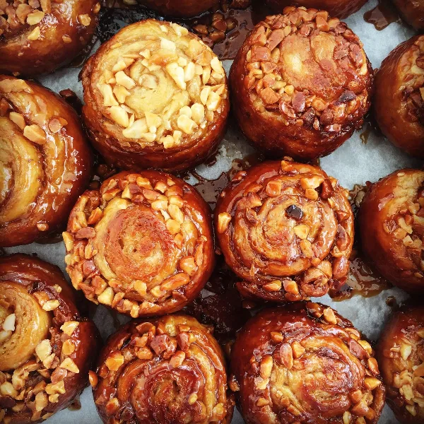 Close-up of glazed baked pastries topped with chopped nuts