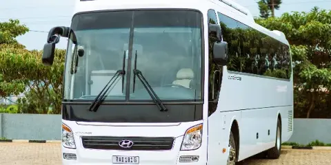 A white Hyundai Universe charter motor coach parked on a paved surface.