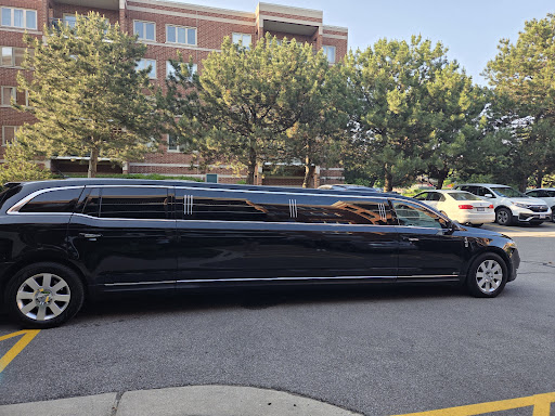A black stretch limousine parked in a parking lot.