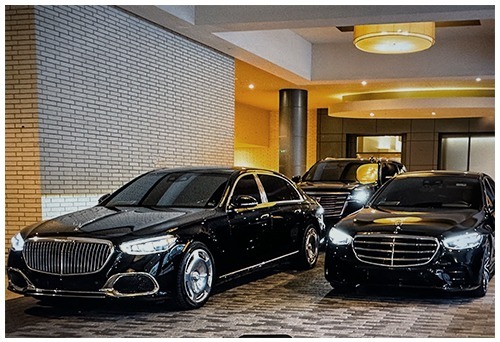 A group of black luxury sedans parked in a modern lobby or garage.