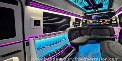 Interior of a luxury party bus with leather seating, a bar, and LED lighting.