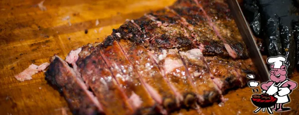 Close-up of sliced barbecue meat on a wooden cutting board