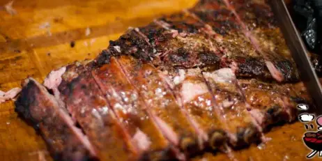 Close-up of sliced barbecue meat on a wooden cutting board