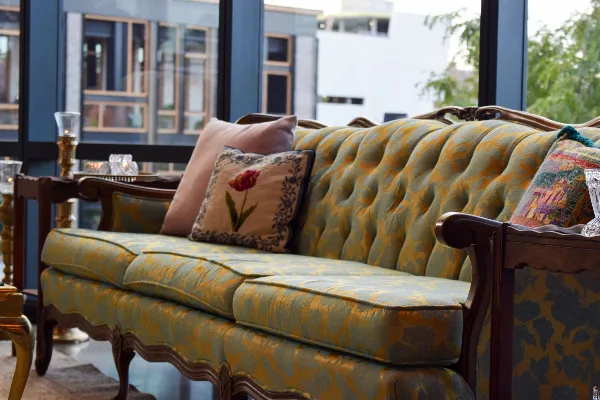 A patterned upholstered sofa with decorative pillows displayed in a rental showroom setting
