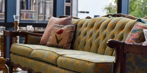 A patterned upholstered sofa with decorative pillows displayed in a rental showroom setting