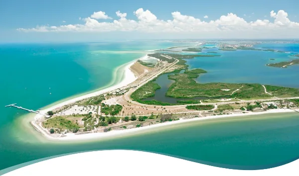 Aerial view of a Pinellas County coastal park with white sand beaches, turquoise water, and green preserves.