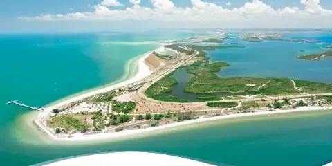 Aerial view of a Pinellas County coastal park with white sand beaches, turquoise water, and green preserves.